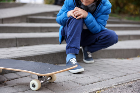 Little boy with skateboard on stairs outdoors, closeup.の写真素材