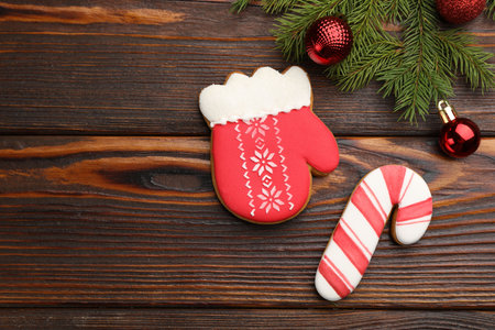 Tasty gingerbread cookies and Christmas decor on wooden table, flat lay. Space for textの写真素材