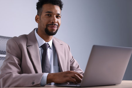 African-American man using laptop at wooden tableの写真素材