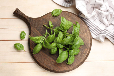 Fresh basil leaves on light wooden table, flat layの写真素材