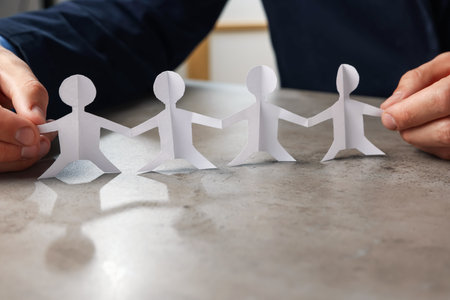 Man with human figures at gray table, closeupの写真素材