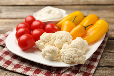 Different fresh vegetables and sauce on wooden table, closeupの写真素材