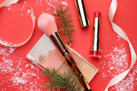 Makeup products, brush and Christmas decor on red background, flat layの写真素材