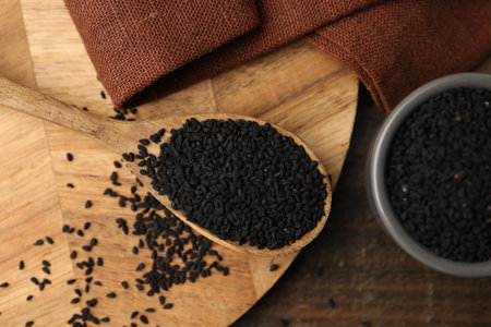 Aromatic black caraway in bowl and spoon on wooden table, top viewの写真素材