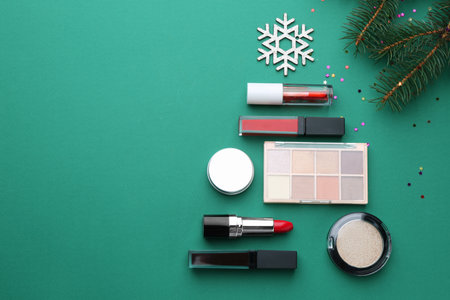 Christmas tree made with makeup products and fir branches on green background, flat lay. Space for textの写真素材