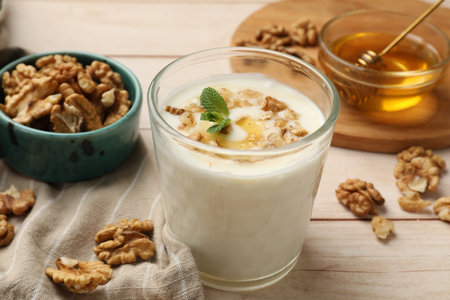 Delicious Greek yogurt with honey and walnuts served on white wooden table, closeupの写真素材