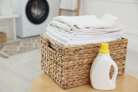 Laundry basket with clean clothes and detergent indoorsの写真素材