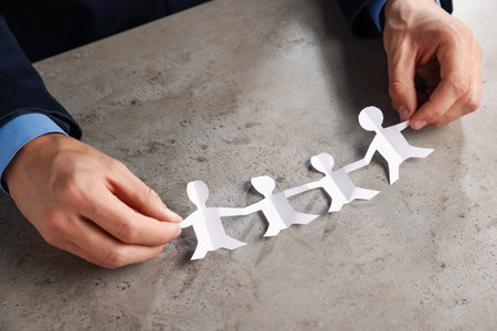 Man with human figures at gray table, closeupの写真素材