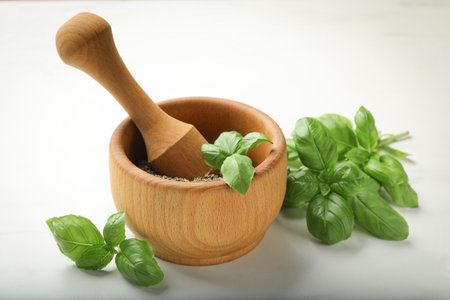Dry basil leaves, fresh ones and mortar on light table, closeupの写真素材