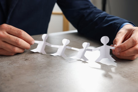 Man with human figures at gray table, closeupの写真素材