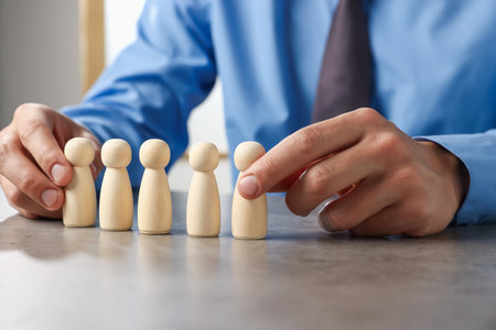 Man with human figures at gray table, closeupの写真素材