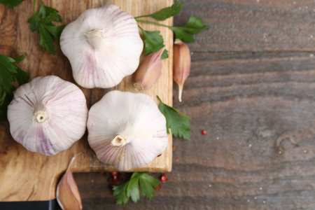 Fresh garlic and parsley on wooden table, flat lay. Space for textの写真素材