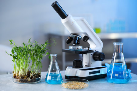 Microscope, product samples and liquids on table in laboratoryの写真素材