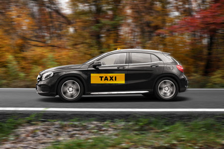 Car with top sign and logo driving on road. Motion blur effect