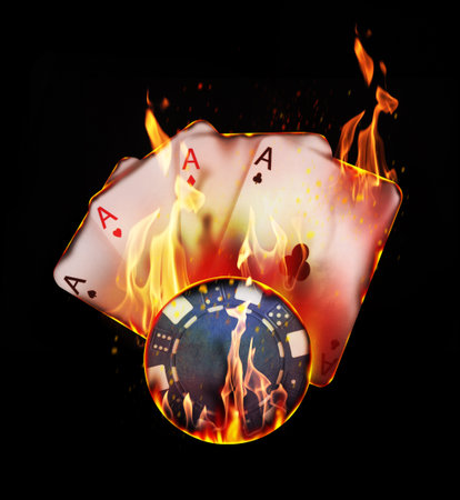 Poker chip and playing cards in flames on black background. Gambling game