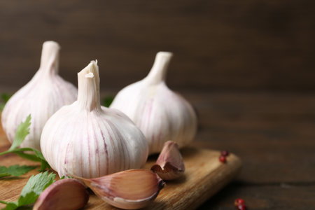 Fresh garlic and parsley on wooden table, closeup. Space for textの写真素材