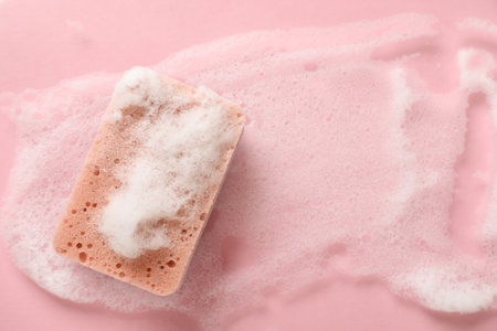Kitchen sponge with foam on pink background, top viewの写真素材