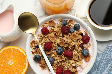 Tasty breakfast. Granola with yogurt and fruits served on white marble table, flat lay