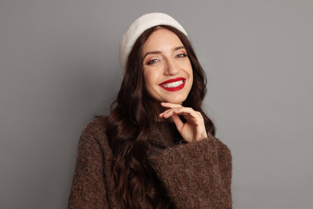 Portrait of beautiful woman with Santa hat on gray background. Christmas seasonの写真素材