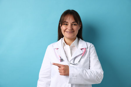 Doctor in medical uniform with stethoscope on light blue backgroundの写真素材