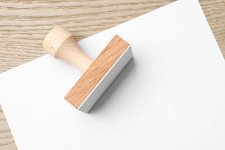 One wooden stamp and blank sheet of paper on table, top view. Space for textの写真素材