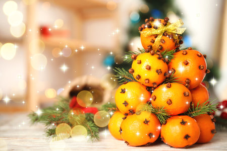 Christmas tree made of tangerines with cloves on table. Bokeh lightsの写真素材