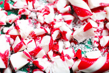 Pile of crushed candy canes on green background, closeup. Christmas treatの写真素材
