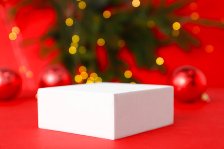 Empty podium and Christmas decor on red background, selective focusの写真素材
