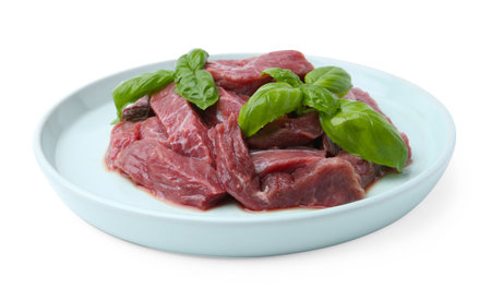 Pieces of raw beef meat and basil isolated on whiteの写真素材