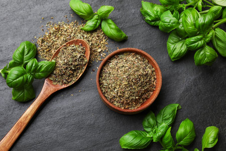 Fresh and dry basil on black textured table, flat layの写真素材