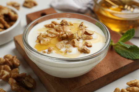Delicious Greek yogurt with honey and walnuts served on white table, closeupの写真素材