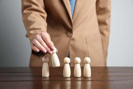 Woman with human figures at wooden table, closeupの写真素材