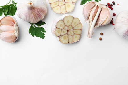Garlic, peppercorns and parsley on white table, flat lay. Space for textの写真素材
