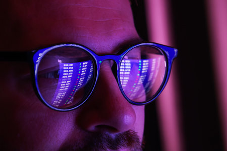 Man wearing glasses with reflection in darkness, closeup. Space for text