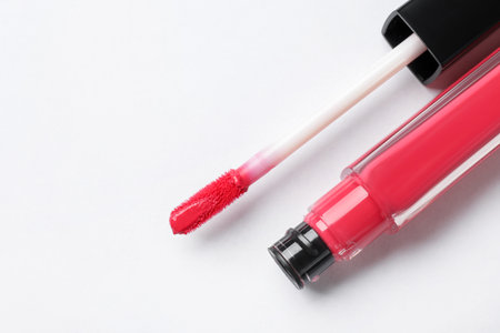 Beautiful lip gloss with applicator on white background, top view. Space for textの写真素材