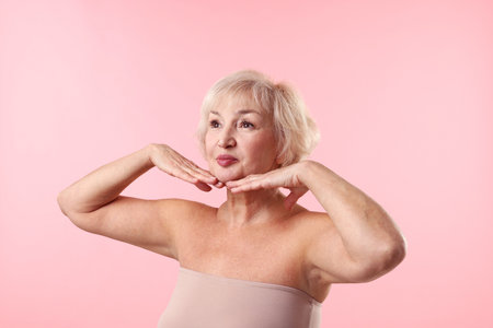 Beautiful senior woman on light pink backgroundの写真素材