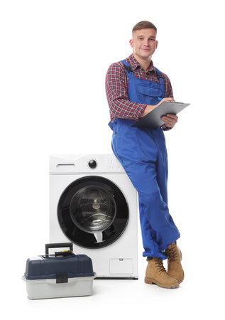 Repairman in uniform with pen, clipboard, toolbox and washing machine on white backgroundの写真素材