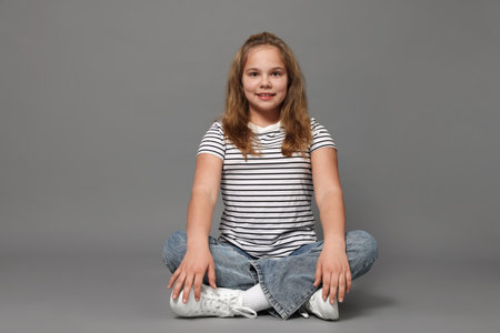 Portrait of cute girl on gray backgroundの写真素材