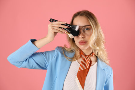 Makeup artist with set of brushes on pink background