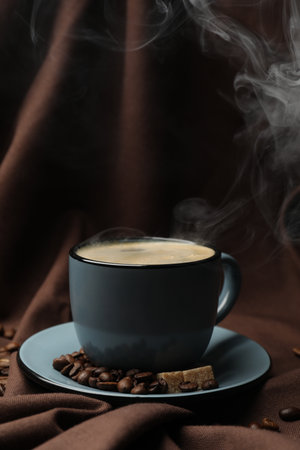 Aromatic coffee in cup, beans and brown sugar on fabric, closeupの写真素材