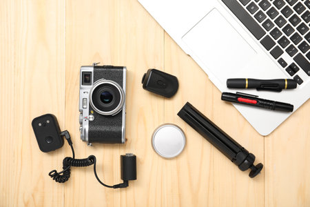 Professional photographer's equipment on wooden background, flat lay