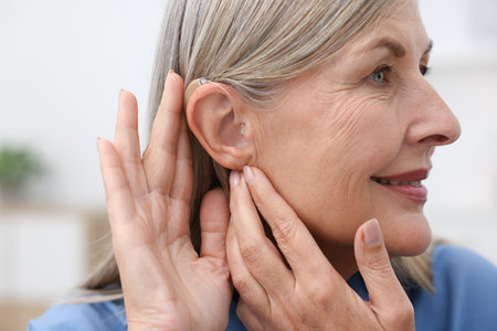 Senior woman with hearing aid at home