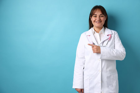 Doctor in medical uniform with stethoscope on light blue background, space for textの写真素材