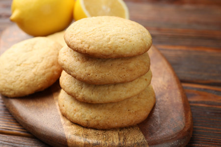 Tasty lemon cookies and fruits on wooden table, closeup