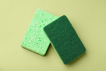 Kitchen sponges on light green background, top view