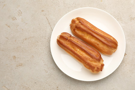 Tasty eclairs on light table, top view. Space for text