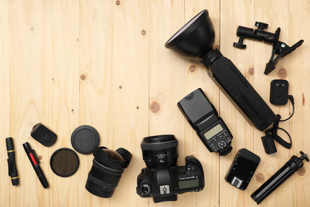 Professional photographer's equipment on wooden background, flat lay. Space for textの写真素材