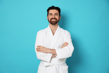 Man in bathrobe on light blue backgroundの写真素材