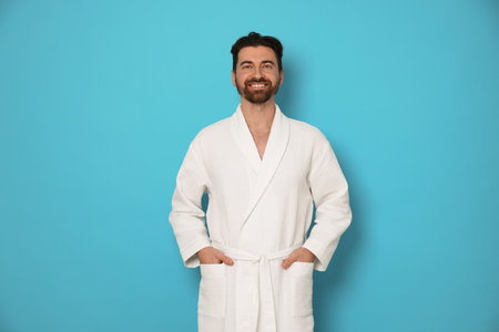 Man in bathrobe on light blue backgroundの写真素材