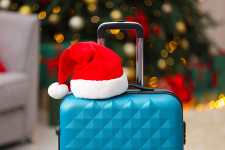 Christmas vacation. Suitcase with Santa hat indoors, closeupの写真素材